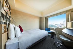 a hotel room with a bed and a desk and a window at ANA Crowne Plaza Kanazawa by IHG in Kanazawa