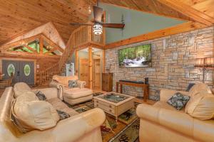 ein Wohnzimmer mit Sofas und einer Steinmauer in der Unterkunft Now and Forever cabin in Sevierville