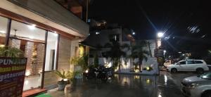a street at night with a car parked outside a building at Hotel Samrat in Dehradun