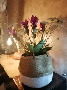 un jarrón lleno de flores sentado en una mesa en Hotel Petit, en Silvi Marina