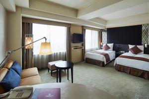 a hotel room with two beds and a table at ANA Crowne Plaza Kanazawa by IHG in Kanazawa