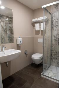 a bathroom with a toilet, sink, and shower at Hotel Della Rosa in Ancona