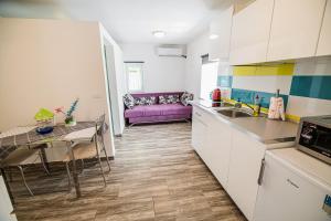 a kitchen with a table and a purple couch at CUDERLAND STUDIO KURNIK in Kobarid