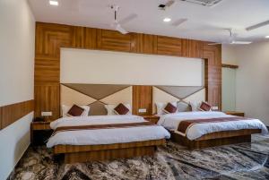 two beds in a large room with wooden walls at Komal Inn in Pushkar +60 photos