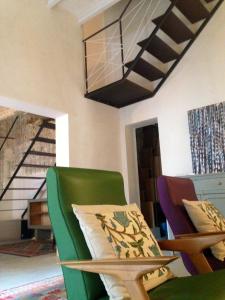uma sala de estar com uma cadeira verde e uma mesa em Casa vacanze "Officina del fabbro" - Menfi em Menfi