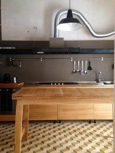 a kitchen with a wooden table and a sink at Casa vacanze "Officina del fabbro" - Menfi in Menfi