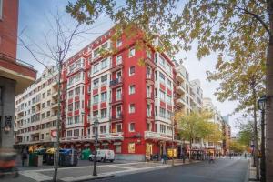 czerwony budynek po stronie ulicy miejskiej w obiekcie Estrena Glamour y Guggenheim by the urban hosts w mieście Bilbao