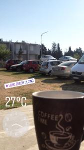 a cup of coffee sitting next to a parking lot at Rooms Ajllin in Ulcinj