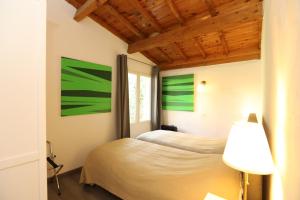 dwa łóżka w pokoju z zielonymi obrazami na ścianie w obiekcie Villa Rouvesol w mieście Saint-Romain-de-Lerps