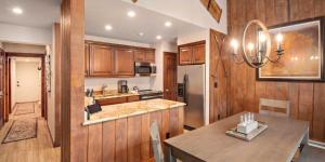 a kitchen with wooden cabinets and a dining table at Vantage Point #602 Condo in Vail