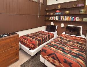 a room with two beds and a dresser and book shelves at Vantage Point 210 Condo in Vail +14 photos
