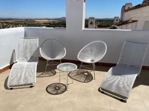 drie stoelen en een tafel en stoelen op een balkon bij Mirador Deluxe in Segura de León