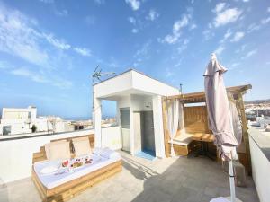 a balcony with a bed and a table on a roof at SUNNY DAY Deluxe in La Playa de Arguineguín
