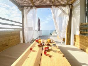 a wooden table with glasses of wine on a balcony at Sunny Day Deluxe in La Playa de Arguineguín