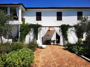 a white house with a red brick walkway at Apartments Relax Zone in Umag