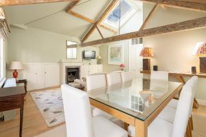 a dining room with a glass table and white chairs at Striking flat near Buckingham Palace in London