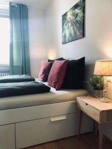 a bed with pink and black pillows and a table at Mida Gästehaus in Freiburg im Breisgau