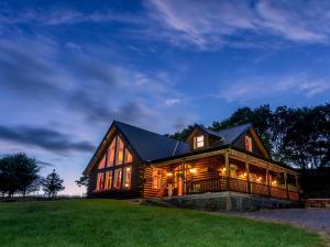 une grande maison en bois sur un champ herbeux dans l'établissement Eaglewood Lodge, à Carrowkennedy