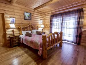 a bedroom with a bed in a log cabin at Eaglewood Lodge Connemara and Mayo in Carrowkennedy