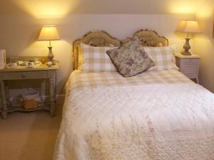a bedroom with a bed with two night stands and two lamps at Sycamore cottage in Matlock