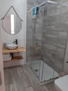 W łazience znajduje się prysznic ze szklanymi drzwiami. w obiekcie Apartamentos San Juan w mieście Arnuero