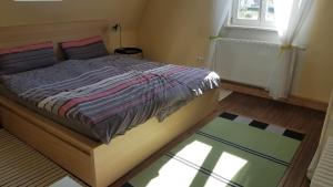 a bedroom with a large bed with a window and a rug at Haus Fink in Volkach