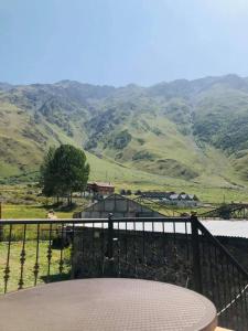 a balcony with a table and a view of a mountain at Wander Kazbegi Hotel in Stepantsminda