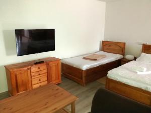 a room with two beds and a flat screen tv at Hotel Na Šustně in Krupá
