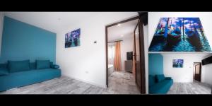 a living room with a blue couch and a mirror at Vila H2O in Mangalia