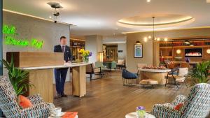 a man standing at a counter in a lobby at Shannon Springs Hotel in Shannon