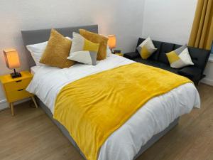 une chambre avec un grand lit avec une couverture jaune dans l'établissement Balco City Living, à Nottingham