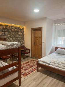 1 Schlafzimmer mit 2 Betten und Ziegelwand in der Unterkunft Riverside Guesthouse in Vusanje