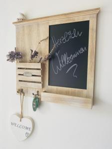 a chalkboard sign in a wooden frame on a wall at Spreewaldferienhäuser am Deich in Lübben