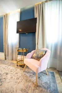 uma sala de estar com uma cadeira rosa e uma mesa em Casa do Estanco em Quiroga