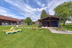 a yard with a pavilion with benches and a fire pit at Keilhof in Seebruck