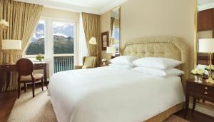 a bedroom with a large white bed and a window at Badrutt's Palace Hotel St Moritz in St. Moritz