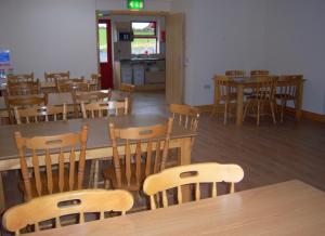 a dining room with wooden tables and chairs at Valley Lodge Farm Hostel in Claremorris