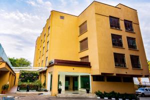 a large yellow building with at Canary Hotel Kampala in Kampala