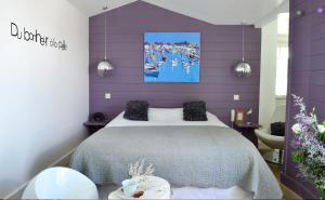 a purple bedroom with a bed and a purple wall at Hotel Les Bois Flottais in Le Bois-Plage-en-Ré