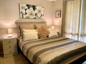 a bedroom with a bed with two lamps on it at Pine View Holiday Rental in Emu Bay