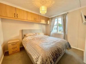 Schlafzimmer mit einem Bett, einem Fenster und einem Kronleuchter in der Unterkunft Modern House in Carlisle close to Lake District in Carlisle