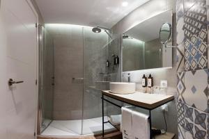 a bathroom with a glass shower and a sink at Petit Palace Ruzafa in Valencia +42 photos
