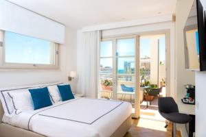 ein weißes Schlafzimmer mit einem Bett und einem Balkon in der Unterkunft Leopoldo Rooms in Cagliari
