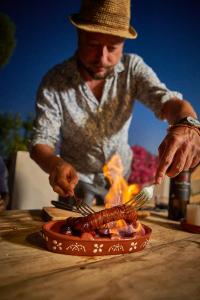 a man is cooking food in a pan on a table at Casa 3 Apartment and Artist Residence in Polopos