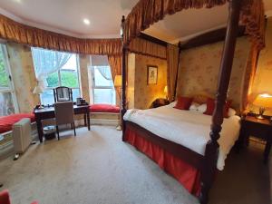 a bedroom with a canopy bed with a desk and a desk at Butlers Townhouse in Dublin