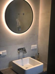 a bathroom with a white sink and a mirror at Appartementen Zer en Loft in centrum Bergen in Bergen +42 photos