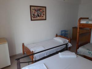 Habitación con 3 camas y una foto en la pared. en Valentina Rooms, en Qeparo