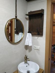La salle de bains est pourvue d'un lavabo et d'un miroir. dans l'établissement Rincón del Viso, à Ourense