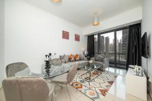 ein Wohnzimmer mit einem Glastisch und Stühlen in der Unterkunft Luton Vacation Homes -Silverene Tower Full marina view ,Dubai Marina A50AB7 in Dubai