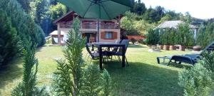 een patio met een tafel en stoelen en een parasol bij Casa Bella in Vadu Moţilor